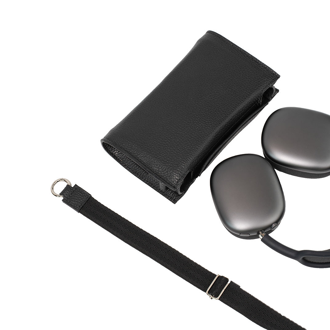 Black leather AirPods Max case with headphones and detachable shoulder strap laid out separately.