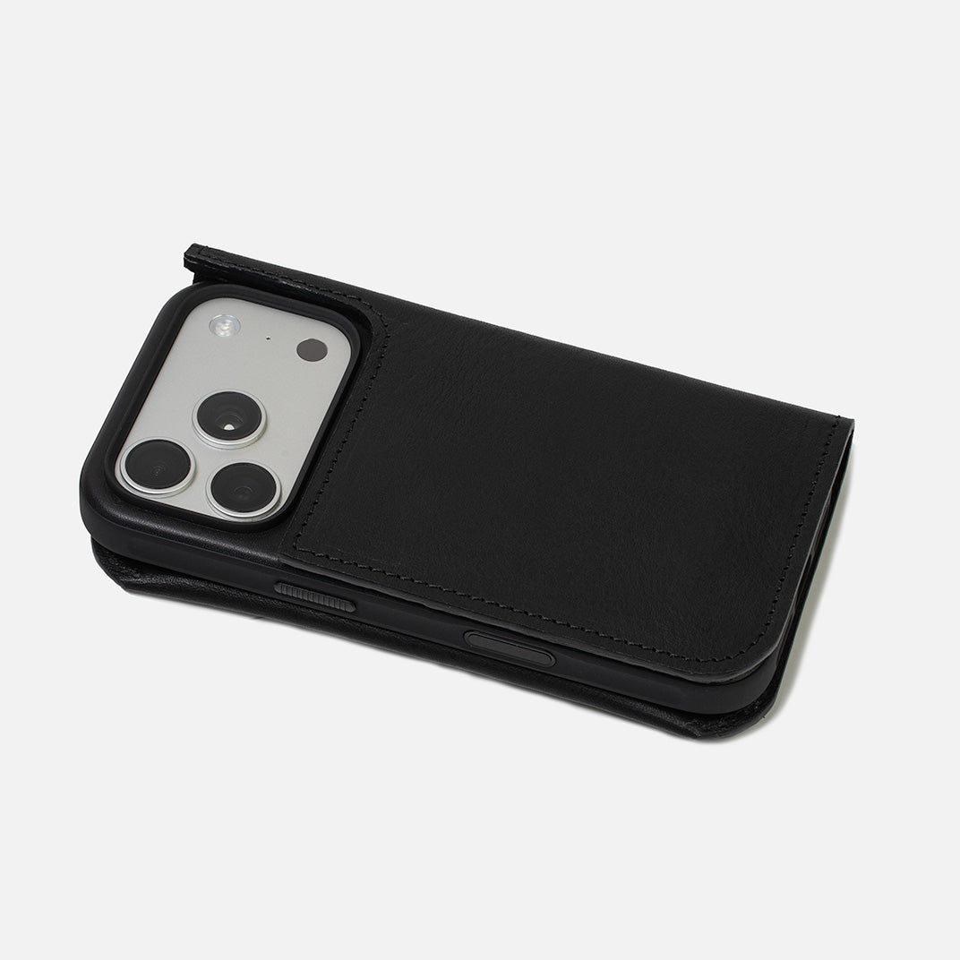 Black leather folio wallet holding a smartphone in a protective case, folded view showing raised camera opening on a white background