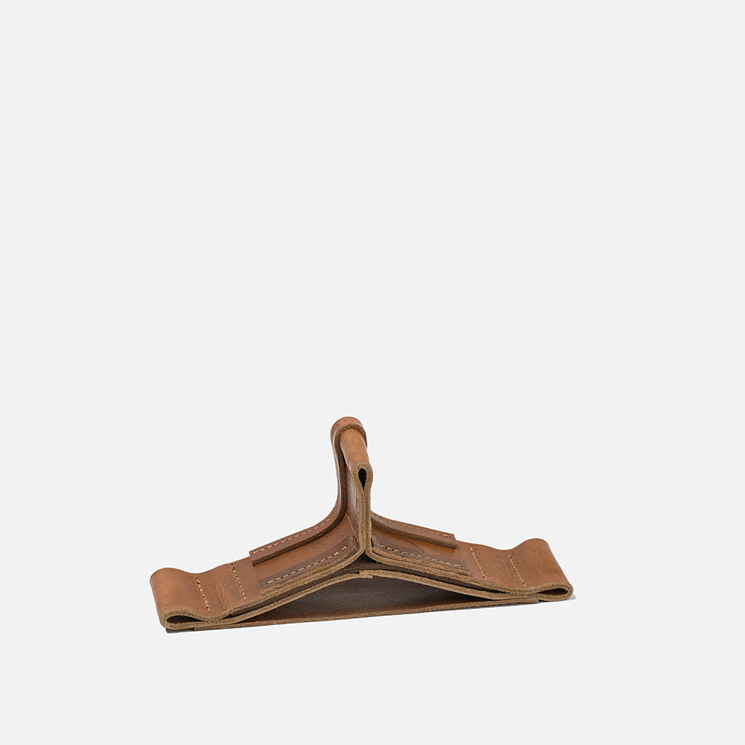 Brown Italian leather AirPods Max stand holding headphones, activating sleep mode and serving as an elegant desktop display