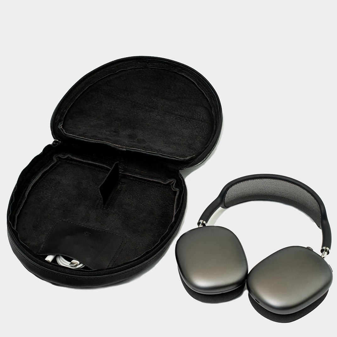 AirPods Max headphones displayed beside their open black leather case, highlighting the spacious interior with a soft lining and compartments for accessories, perfect for protection and convenience