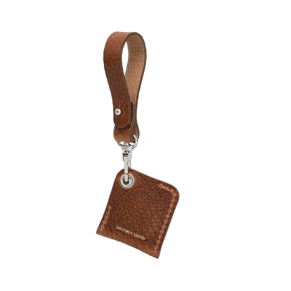 Back of the brown snake-print leather AirTag bag charm, showing the stitched holder and loop strap.