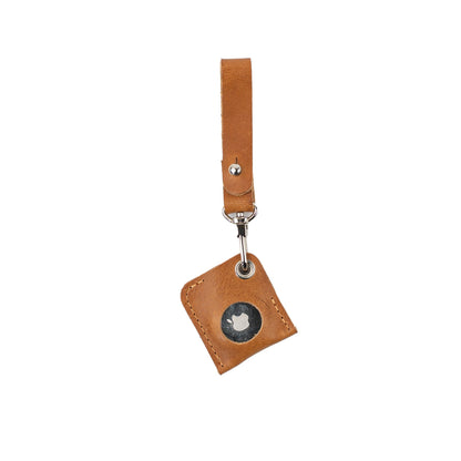 Camel leather AirTag bag charm with a loop strap and silver-tone clasp, showing the metal AirTag face.