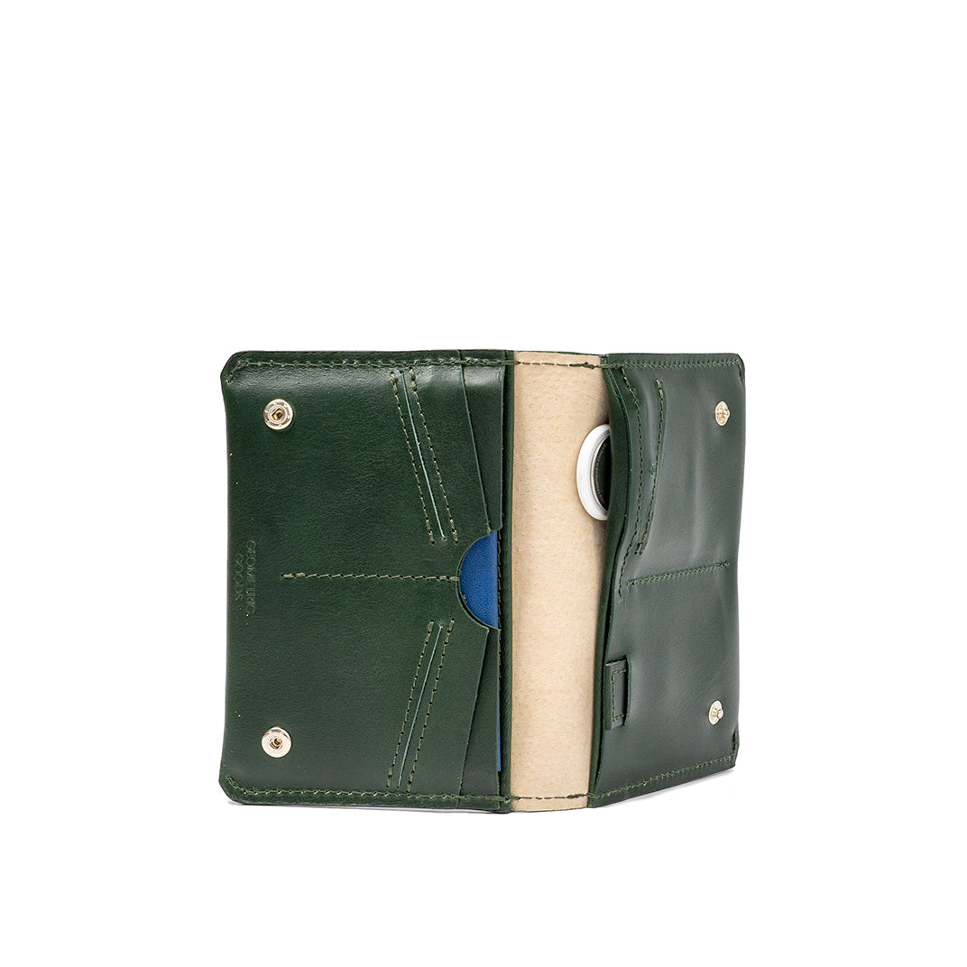 Green leather passport holder with a built-in AirTag slot, offering secure storage for travel documents and easy tracking with an elegant, minimalist design