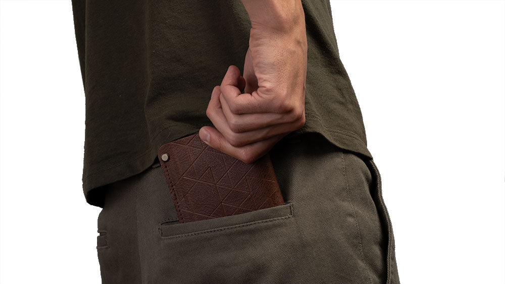 Slim leather AirTag wallet carried in back pocket, compact everyday carry profile