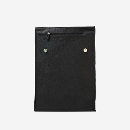 Front view of black leather daypack with magnetic closure and exterior zipper pocket under flap