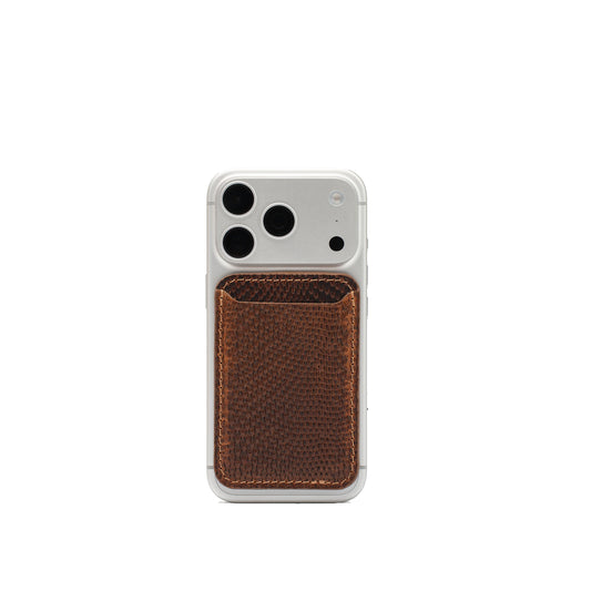 Brown snake-print leather MagSafe wallet attached to the back of a silver iPhone