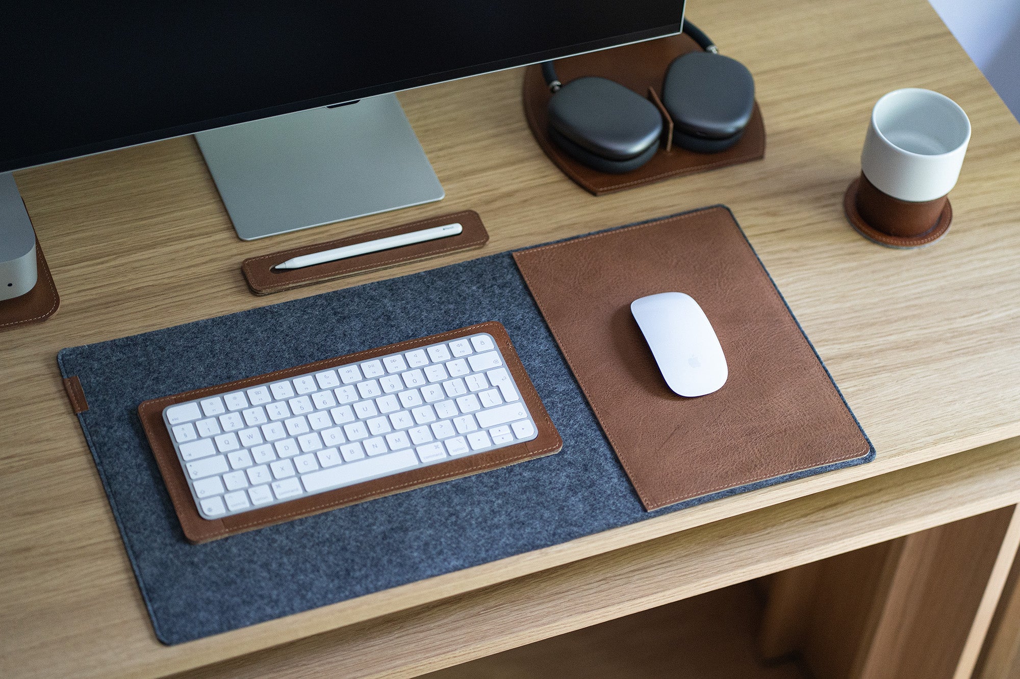 Wool felt desk pad with leather mouse insert on modern workspace
