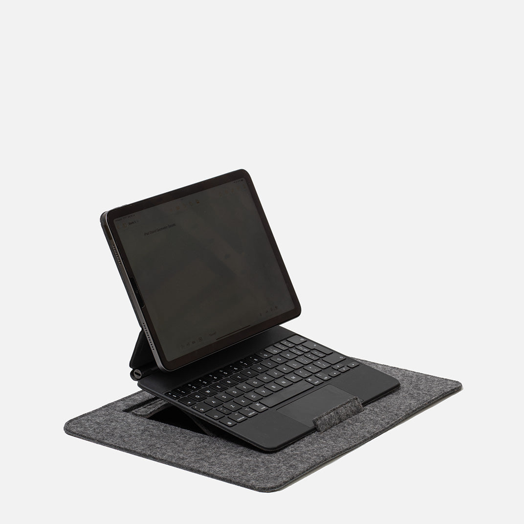 iPad with Magic Keyboard on wool felt desktop stand, showing supported laptop-like setup on grey workspace mat