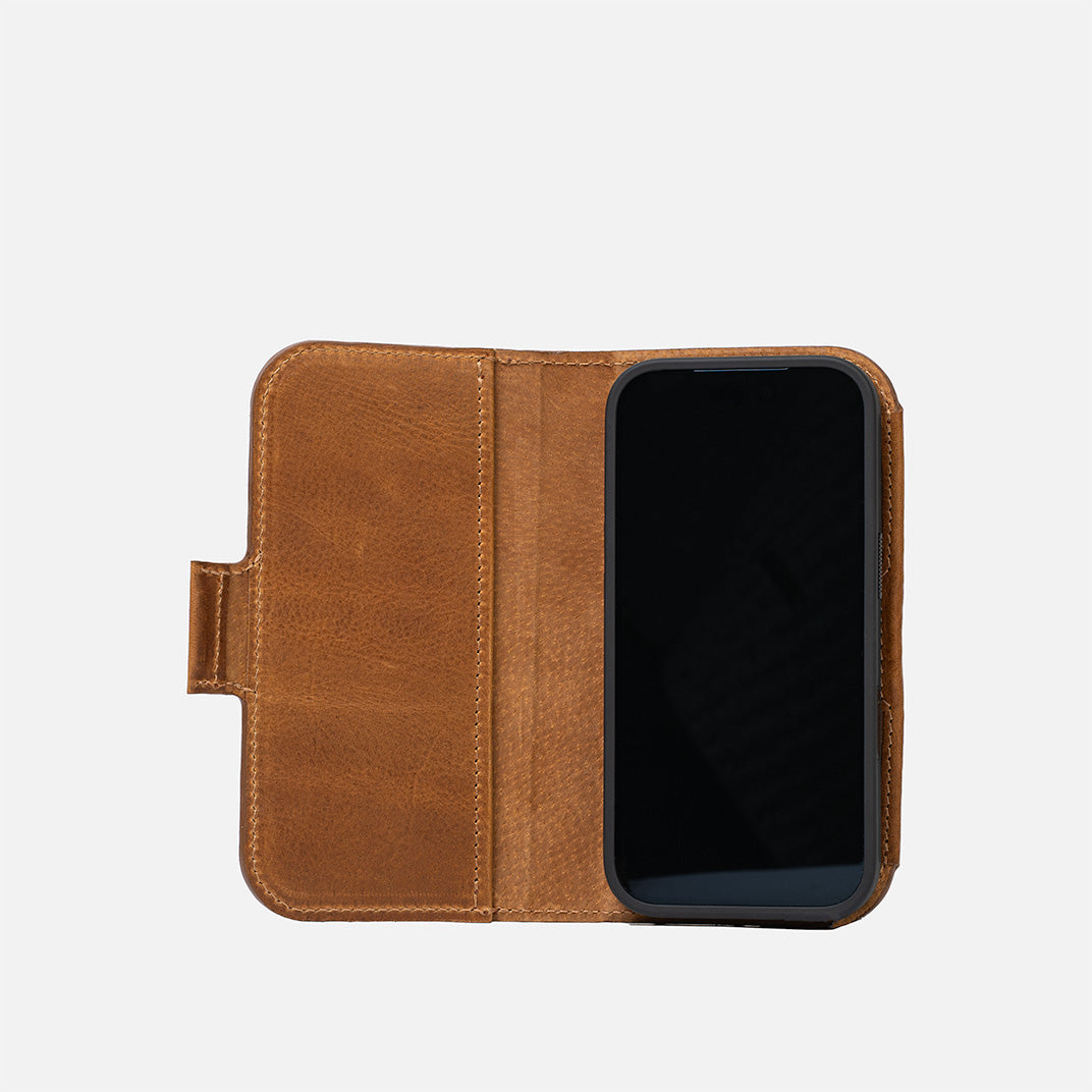 iPhone 17 in open brown leather folio wallet showing interior pocket and tab closure – Geometric Goods