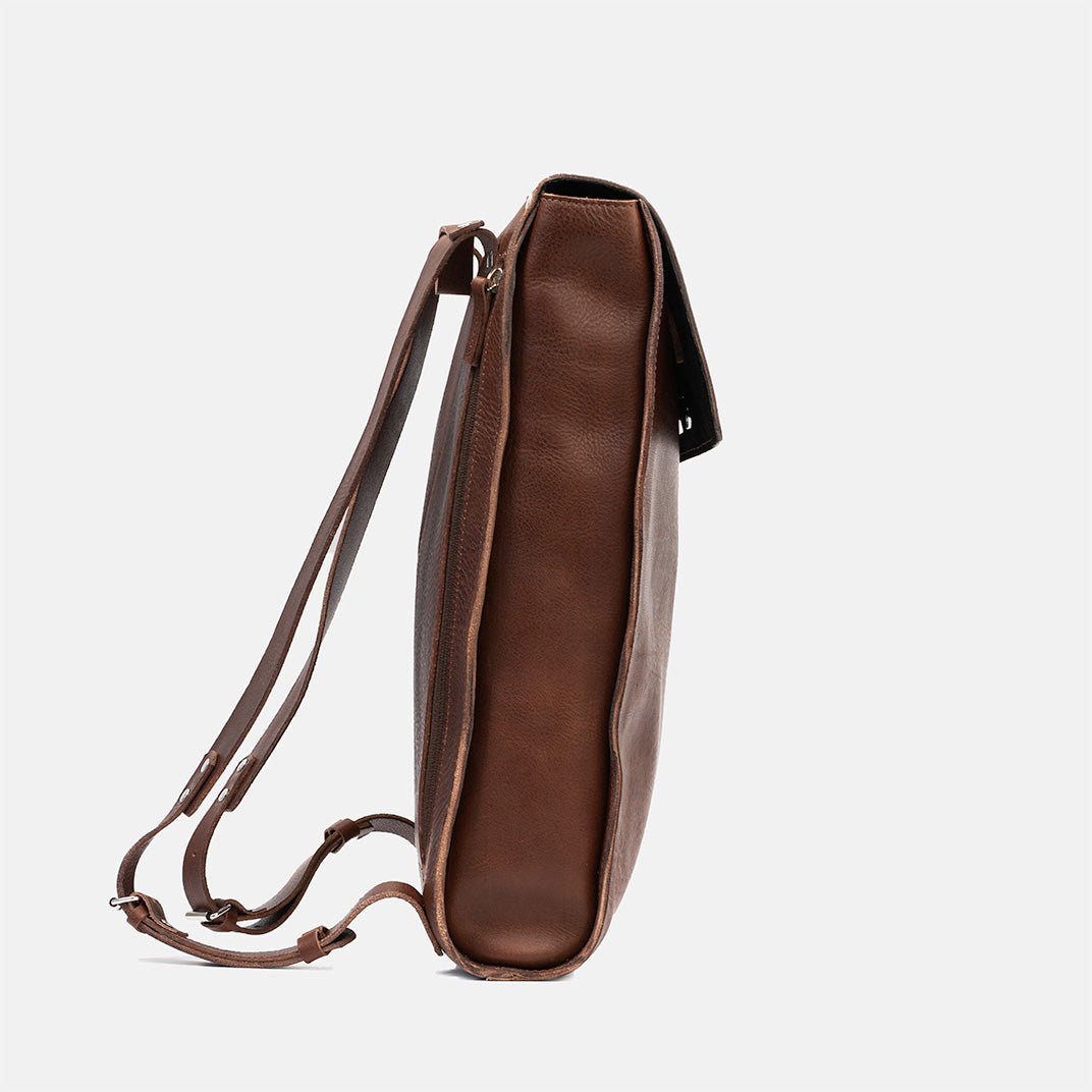 Leather backpack in mahogany, slim side view emphasizing minimalist design, ideal for designers and men's use