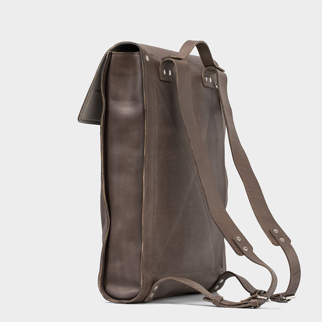 Leather laptop backpack - The Minimalist in gray, side profile view, featuring adjustable straps and premium Italian leather
