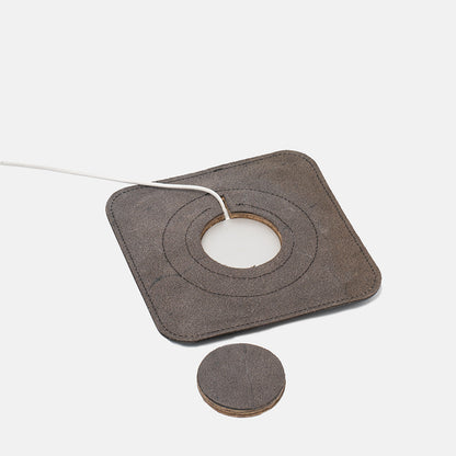 Underside of leather MagSafe charging mat with removable center piece and cable slot visible
