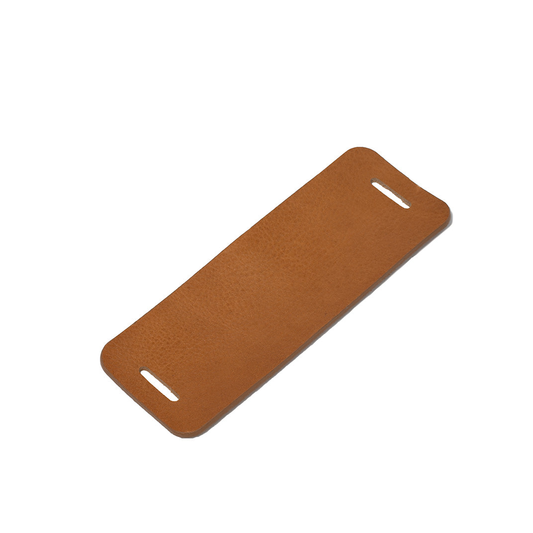 Light brown leather shoulder pad for bag strap on white background
