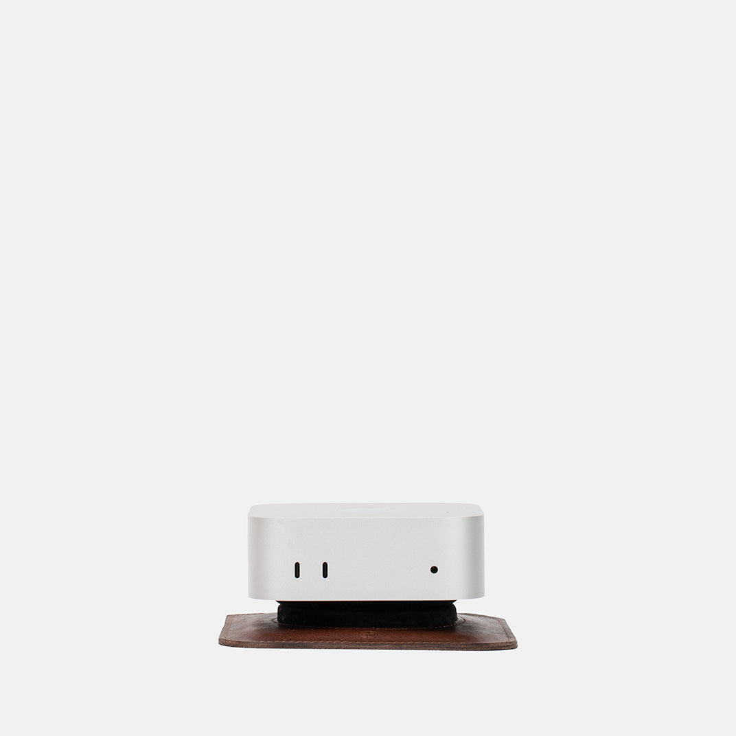 Front view of Mac Mini on The Pedestal stand in mahogany Italian leather by Geometric Goods, highlighting its subtle elevation