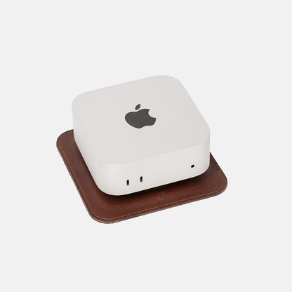 Mac Mini placed on The Pedestal stand in rich mahogany Italian leather by Geometric Goods, showing front and side ports