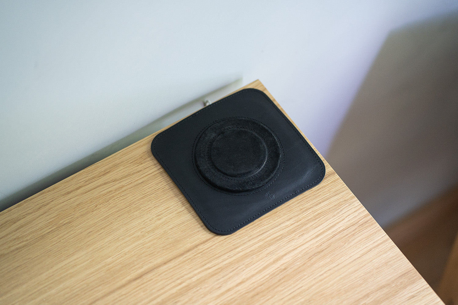 Top view of a black leather desk mat with a circular alignment ring