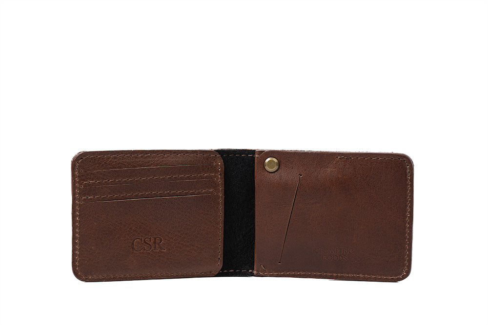 Open brown leather bifold wallet with card slots, bill pocket, and engraved initials