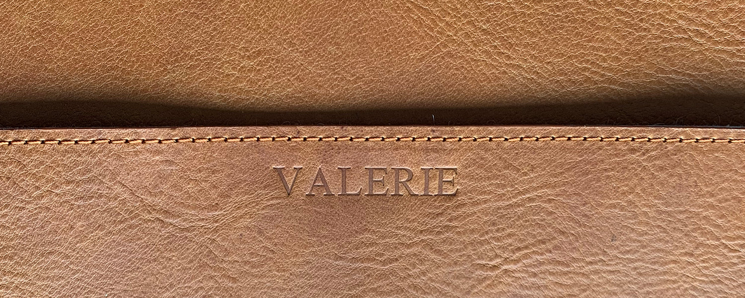 Personalized name engraving on leather, close-up of embossed lettering and stitching