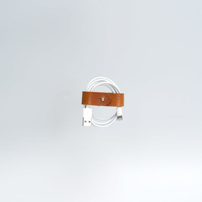 the photo of vintage-style cord organizer made from full-grain leather by Geomeric Goods in tan color