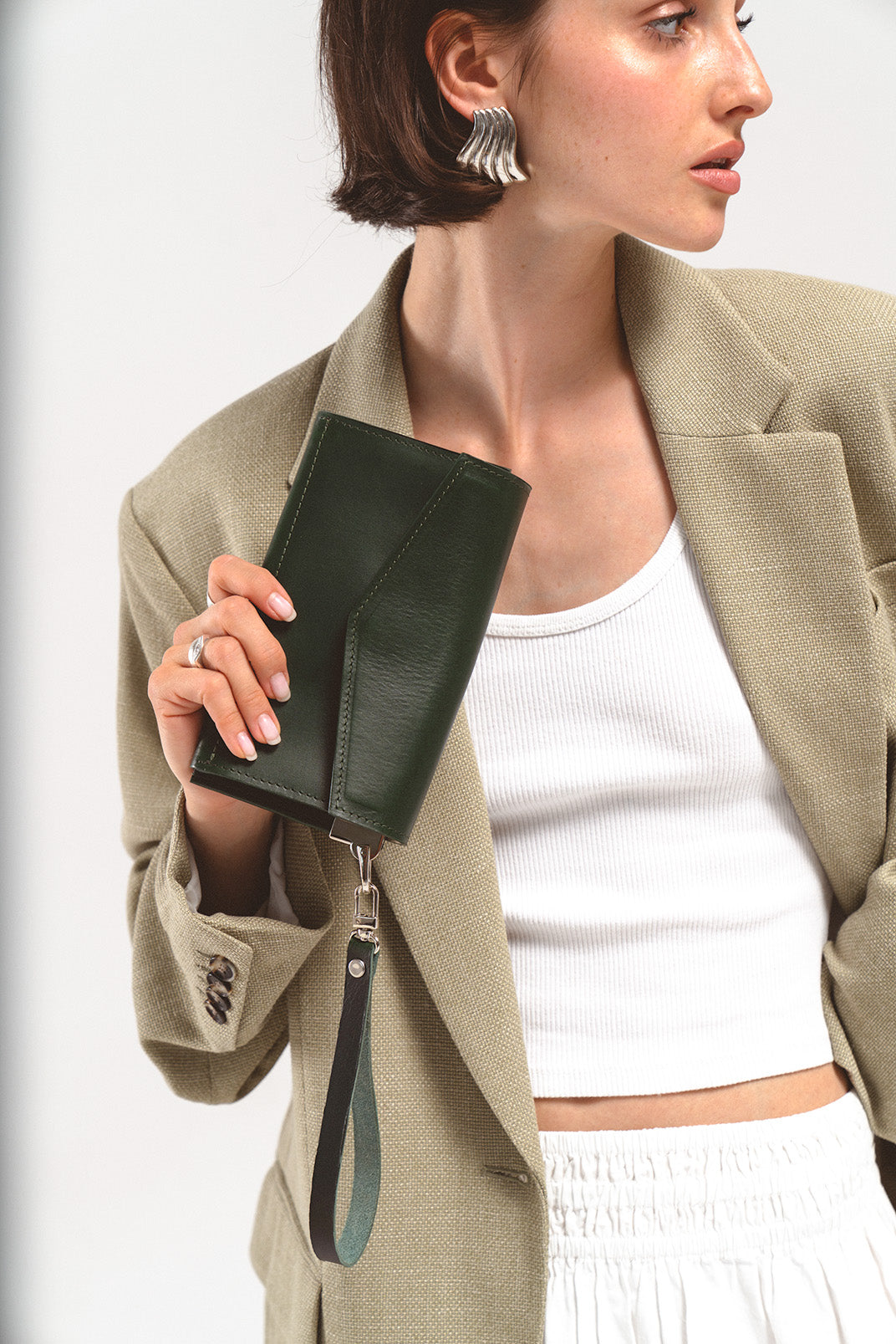 Women's AirTag wallet in dark green leather, featuring ten card slots, three compartments, and a hidden AirTag slot for enhanced functionality and elegance